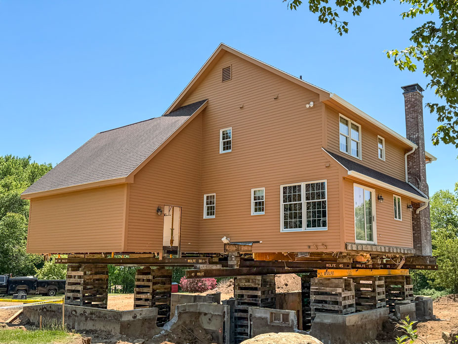 Home on cribbing and lifted with the steel main and croseer beams set underneath the home